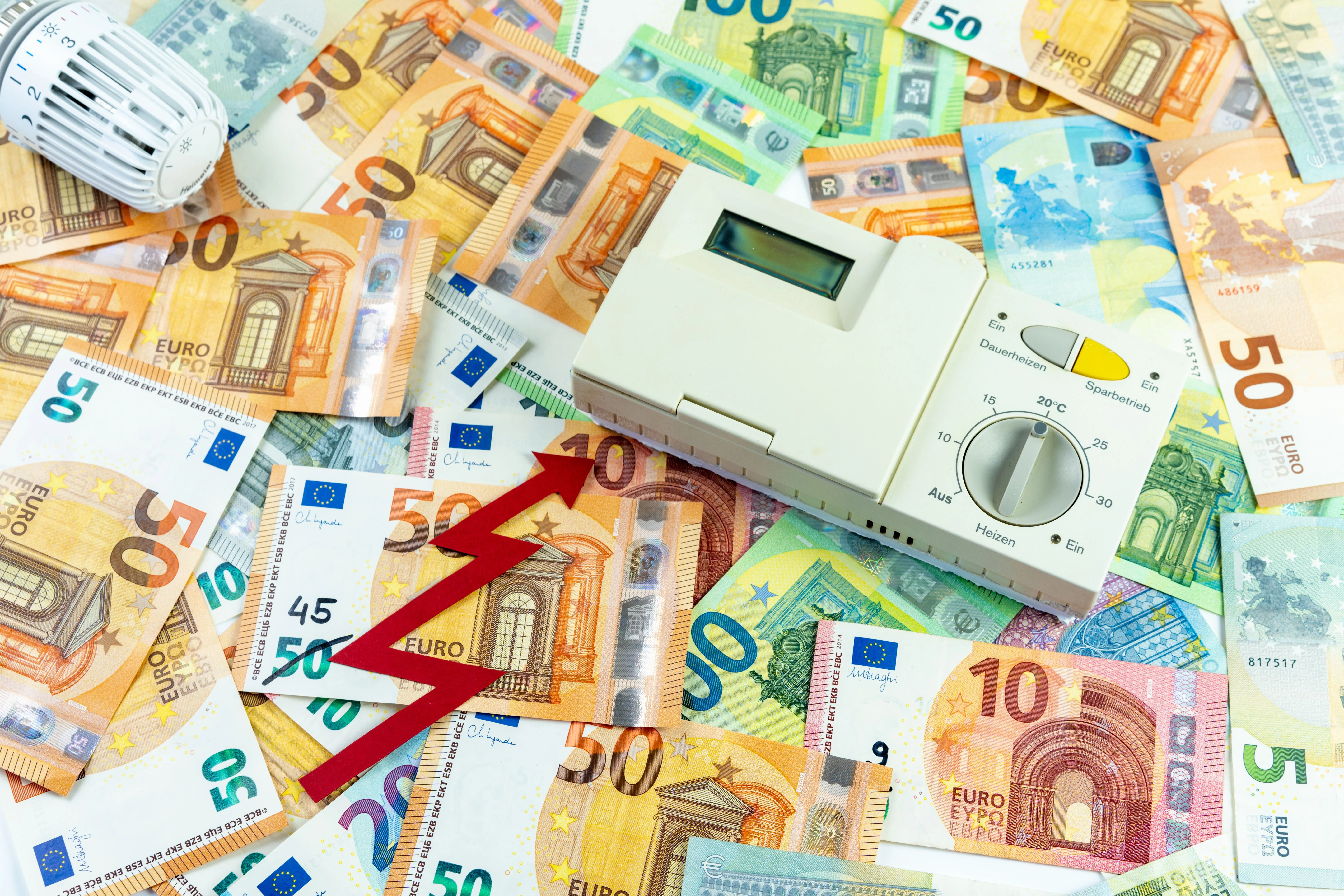 Thermostat numérique sur des billets de 50 euros, symbolisant les économies d'énergie