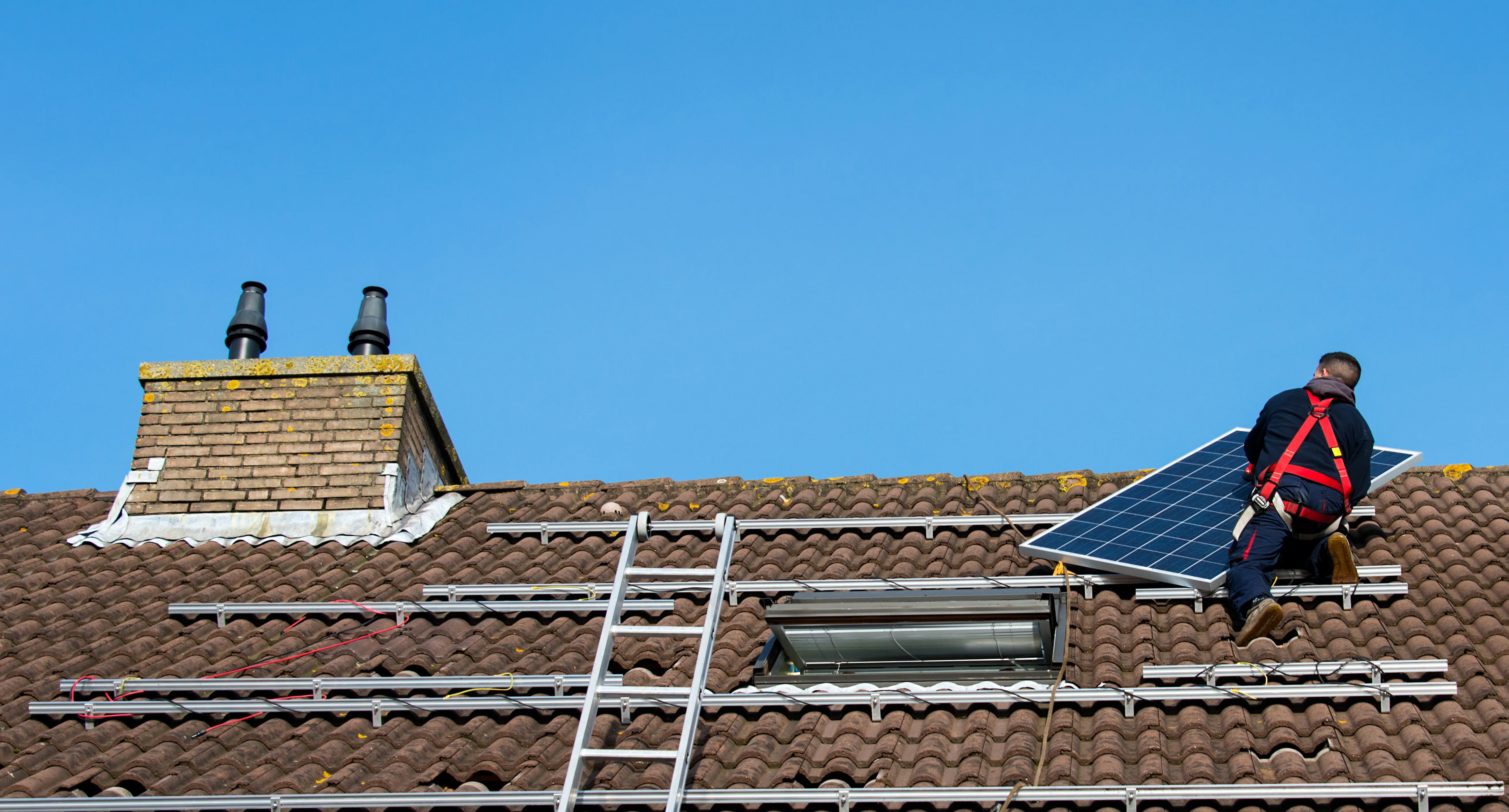 Installation de panneaux solaires sur un toit avec un installateur en sécurité