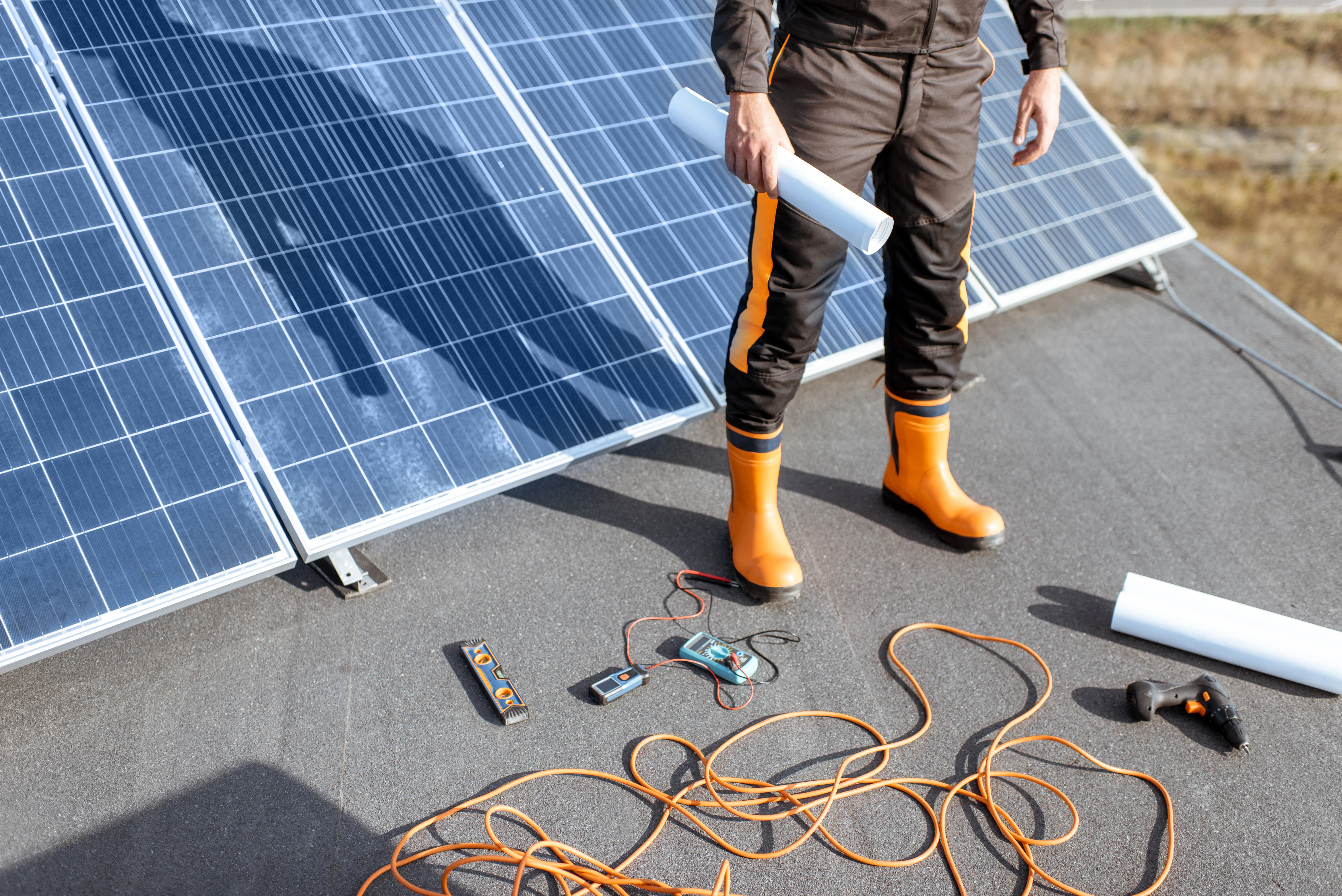 Installation de panneaux solaires sur un toit avec un technicien en tenue de travail