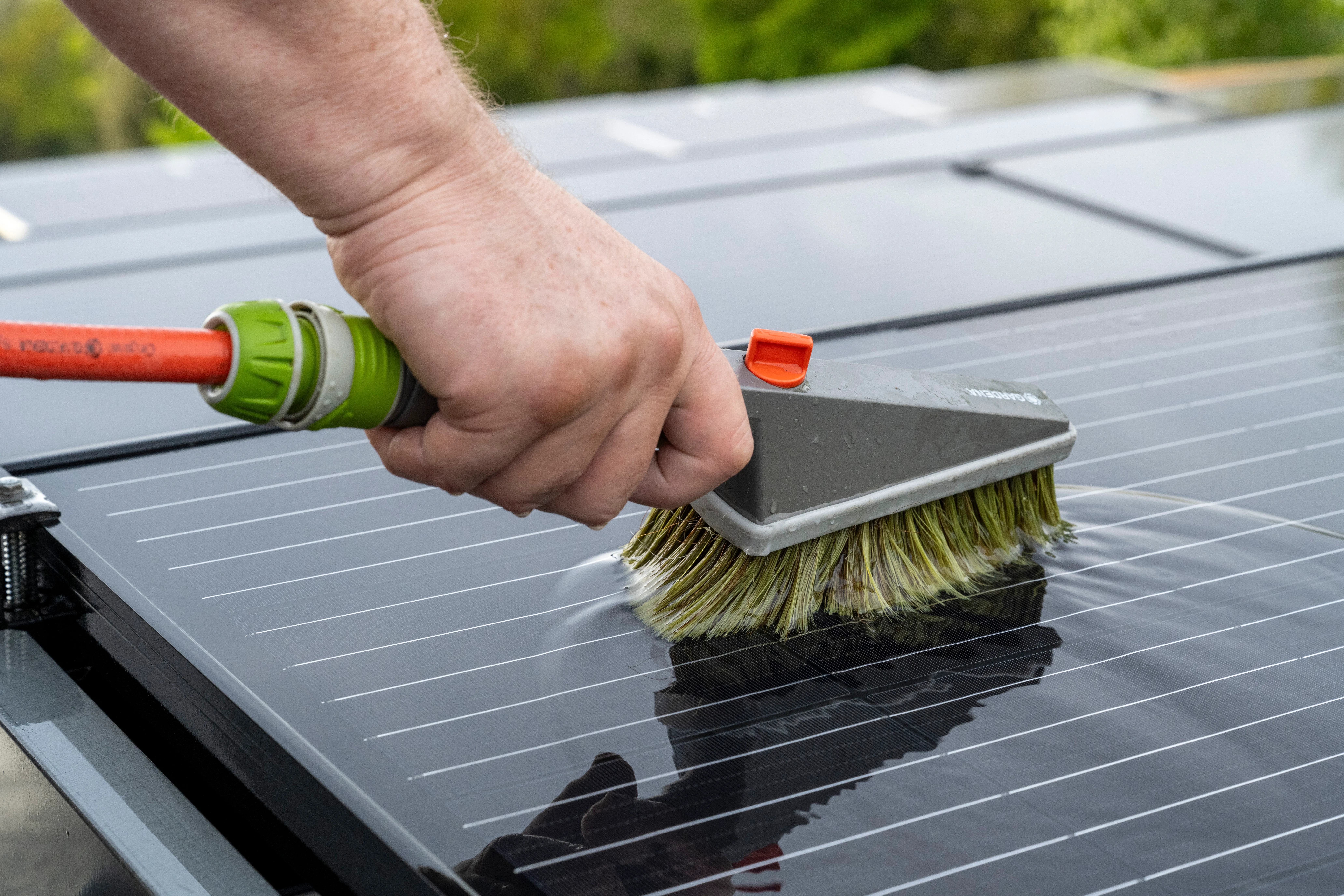 Nettoyage de panneaux solaires avec une brosse sur toiture