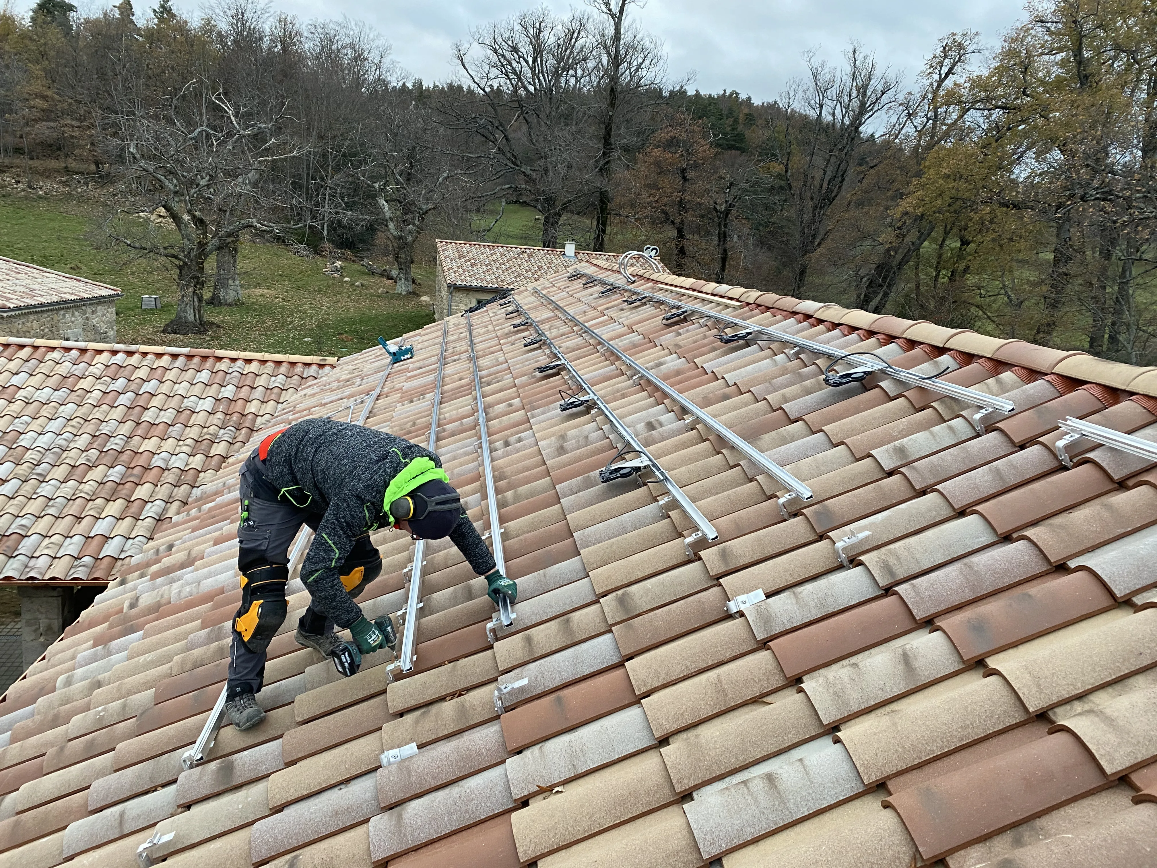Installation de panneaux photovoltaïques sur un toit incliné par un technicien