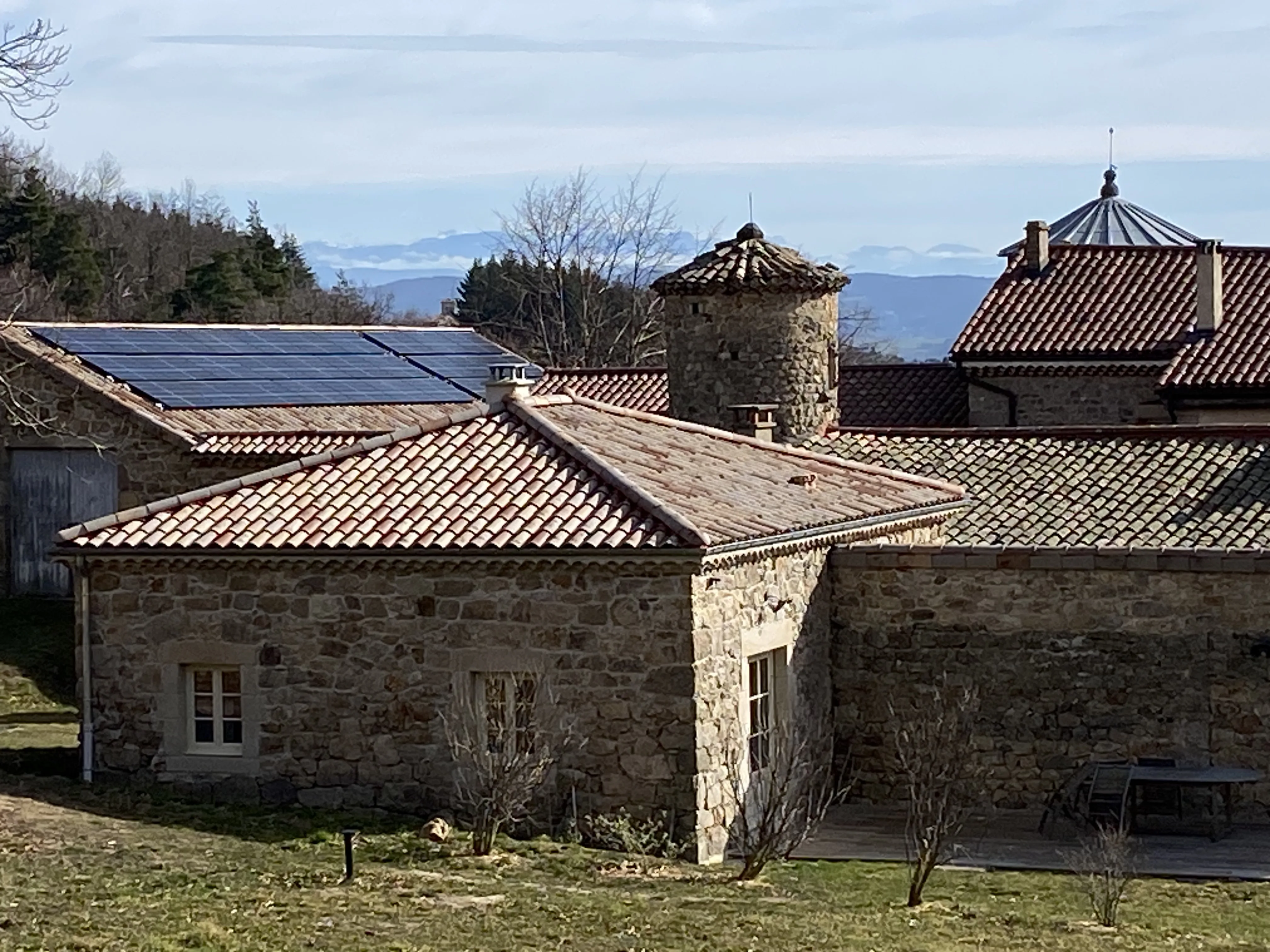 Installation de panneaux solaires sur un toit en pente d'une maison en pierre