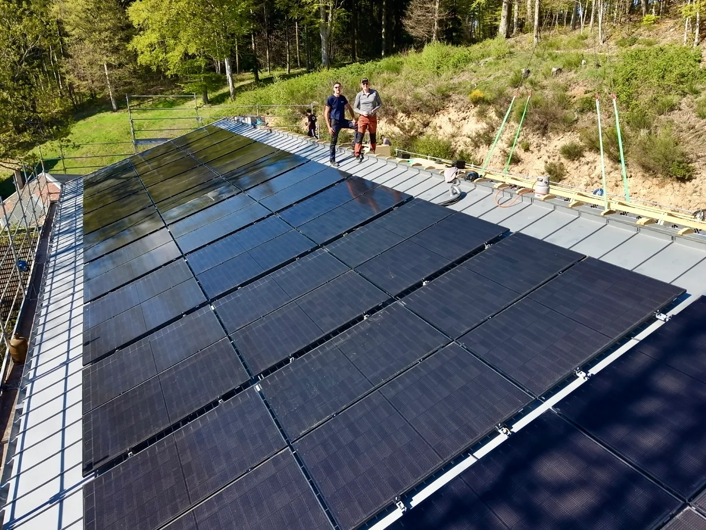 Installation de panneaux photovoltaïques sur toiture inclinée avec deux techniciens