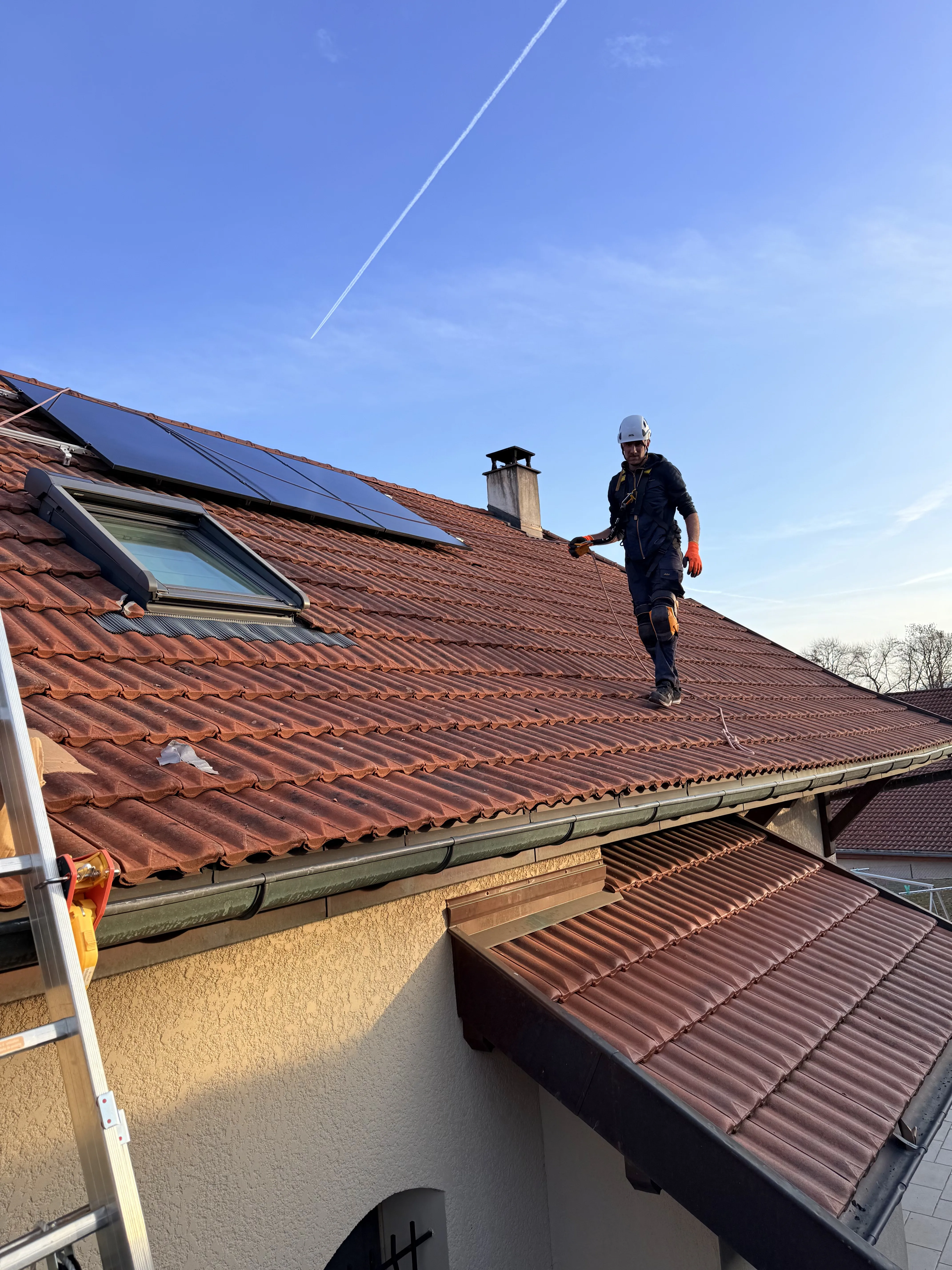 Installation de panneaux photovoltaïques sur toiture inclinée par un technicien